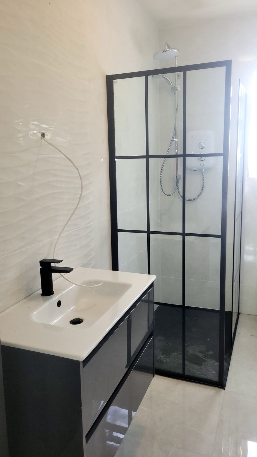 Black-framed shower screen with grey vanity unit
