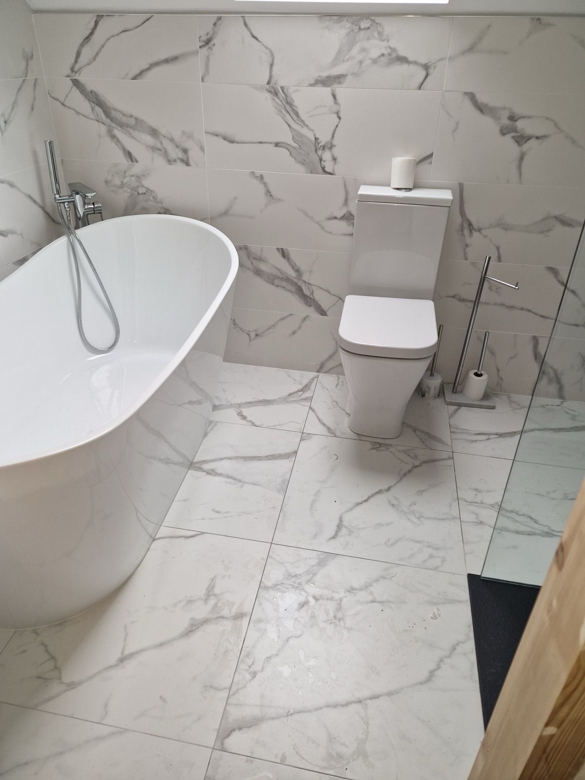 Renovated bathroom with marble tiling and freestanding bath